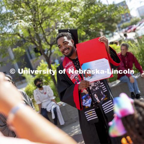 2020 graduate Japrice Ta’Zhon Green shows off his certificate given to all the graduates who returned to campus to walk in the August ceremony. Undergraduate Commencement at Pinnacle Bank Arena. August 14, 2021. Photo by Craig Chandler / University Communication.