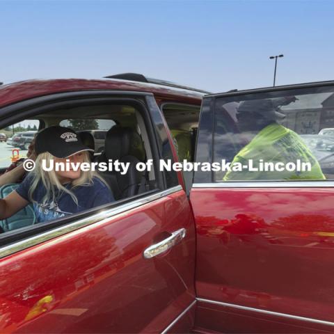 Kenidy Irvine of Grand Island watches as her belongings are unloaded during move-in. Irvine is a First Husker. Early arrival move-in for sorority rush, First Husker and Emerging Leaders. August 15, 2021. Photo by Craig Chandler / University Communication.