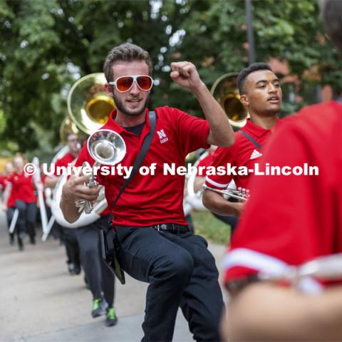Paul Circo gets some air as the band shows a few moves while marching to the stadium. Big Red Welcome week featured the Cornhusker Marching Band Exhibition. The band gave their warm-up concert outside of Kimball Recital Hall and then marched to the stadium. Lightning then caused the show to be cancelled. August 20, 2021. Photo by Craig Chandler / University Communication.