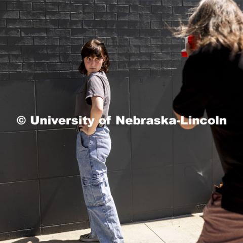 Olivia Jenkins, a sophomore from Lincoln, poses for her photo being taken by Sean Strough, Equipment and Technology Associate for the Johnny Carson Center for Emerging Media Arts. Carson students gathered outside the building Friday afternoon for picture day. The photos were done on old school Polaroid instant film. The images will be posted in the center so all the students can know each other better. August 27, 2021. Photo by Craig Chandler / University Communication.