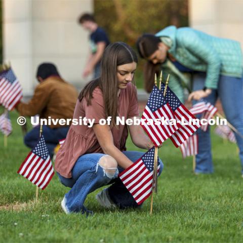 Madi Hadley, a freshman from Gunnison, Colorado, sets up flags in the green space north of the Nebraska Union to commemorate 9/11. Hadley said she has several family members on active duty, and this was a way she could honor their sacrifice. 9/11 memorials. September 9, 2021. Photo by Craig Chandler / University Communication.