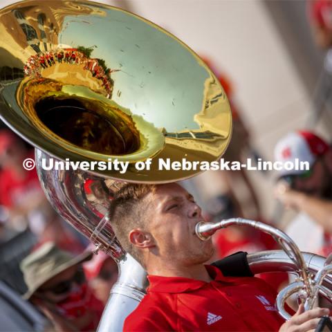 Kason Fiedler, a senior from Lincoln, plays the sousaphone as the Cornhusker Marching Band warms up the crowd at the unity walk. Nebraska vs. Buffalo University game on the 20th anniversary of 9/11. Photo by Craig Chandler / University Communication.