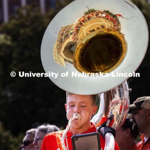 Kason Fiedler, a senior from Lincoln, plays the sousaphone as the Cornhusker Marching Band warms up the crowd at the unity walk. Nebraska vs. Buffalo University game on the 20th anniversary of 9/11. Photo by Craig Chandler / University Communication.