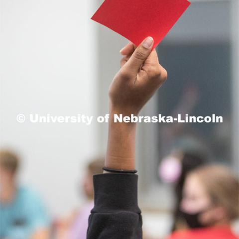 A student holds up a red card in an ALEC 102 class. Hannah Sunderman, Program Director, NHRI Leadership Mentoring and Professor of Practice, works with her ALEC 102 Interpersonal Skills for Leadership class. They were doing a values game. October 7, 2021. Photo by Abby Durheim for University Communication.