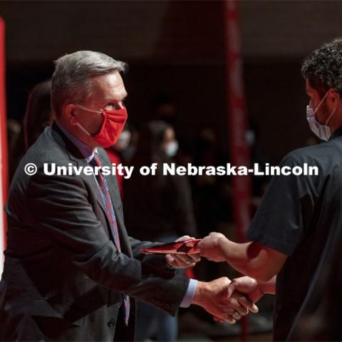 Yael Blanco-Zamudio shakes hands with Chancellor Ronnie Green after receiving his admission certificate at Omaha South. Chancellor Green presented certificates to Nebraska College Preparatory Academy seniors at Omaha South and Omaha North high schools. November 2, 2021. Photo by Craig Chandler / University Communication.