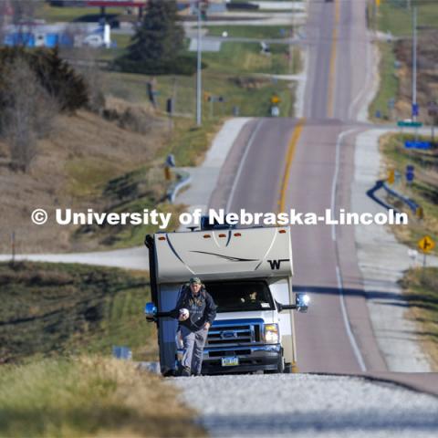 Trevor Stephens, U.S. Marine Corps veteran and a sophomore in secondary education from Council Bluffs, Iowa, walks along Highway 93 westbound from Treynor, Iowa.
Stephens carries the game ball, and 20 pounds in his pack, recognizing the 20 veterans that die from suicide each day. Sixth annual The Things They Carry Ruck March, which began at Kinnick Stadium in Iowa City, Iowa, Nov. 17, and finishes at Memorial Stadium on Friday, Nov. 25. The march, which is organized by the University of Nebraska–Lincoln Student Veterans and University of Iowa Veterans Association organizations, is centered on raising awareness of the epidemic of veteran suicide. It also carries the game ball for the Husker-Hawkeye match-up. November 23, 2021. Photo by Craig Chandler / University Communication.

