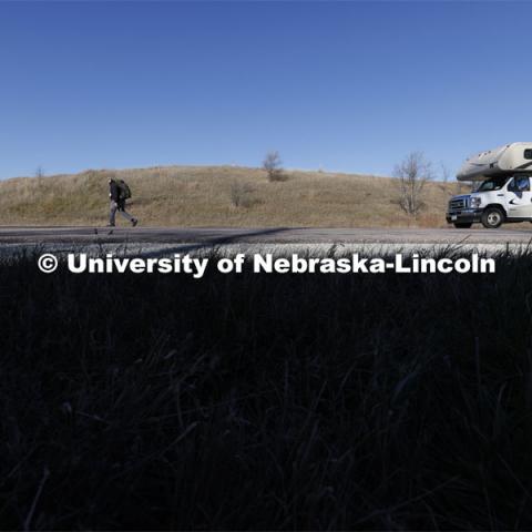 Trevor Stephens, U.S. Marine Corps veteran and a sophomore in secondary education from Council Bluffs, Iowa, walks along Highway 93 westbound from Treynor, Iowa.
Stephens carries the game ball, and 20 pounds in his pack, recognizing the 20 veterans that die from suicide each day. Sixth annual The Things They Carry Ruck March, which began at Kinnick Stadium in Iowa City, Iowa, Nov. 17, and finishes at Memorial Stadium on Friday, Nov. 25. The march, which is organized by the University of Nebraska–Lincoln Student Veterans and University of Iowa Veterans Association organizations, is centered on raising awareness of the epidemic of veteran suicide. It also carries the game ball for the Husker-Hawkeye match-up. November 23, 2021. Photo by Craig Chandler / University Communication.

