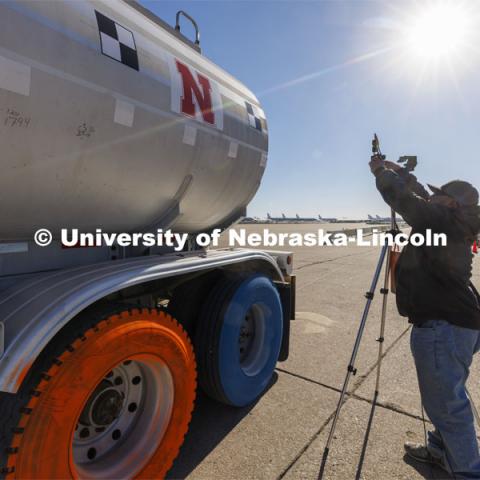 Dave Charrion checks a camera alignment used for a speed check before the tanker was driven back to its starting point. Researchers from the Midwest Roadside Safety Facility conducted a rare tractor-tanker crash to test how a newly designed and significantly less tall concrete roadside barrier performs in a crash. The test was at the facility’s Outdoor Proving Grounds on the western edge of the Lincoln Municipal Airport. December 8, 2021. Photo by Craig Chandler / University Communication.