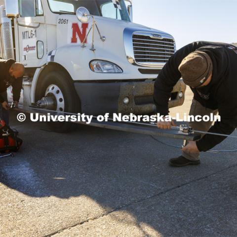 A steering guide which rides along a second cable and keeps the wheels straight is connected before the test. Researchers from the Midwest Roadside Safety Facility conducted a rare tractor-tanker crash to test how a newly designed and significantly less tall concrete roadside barrier performs in a crash. The test was at the facility’s Outdoor Proving Grounds on the western edge of the Lincoln Municipal Airport. December 8, 2021. Photo by Craig Chandler / University Communication.