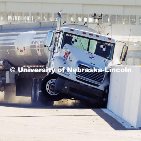 The roadside barrier developed by University of Nebraska–Lincoln researchers holds firm as a fully-loaded tractor-tanker vehicle slams into it during a Dec. 8 test. Researchers from the Midwest Roadside Safety Facility conducted a rare tractor-tanker crash to test how a newly designed and significantly less tall concrete roadside barrier performs in a crash. The test was at the facility’s Outdoor Proving Grounds on the western edge of the Lincoln Municipal Airport. December 8, 2021. Photo by Craig Chandler / University Communication.