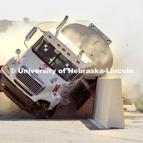 The roadside barrier developed by University of Nebraska–Lincoln researchers holds firm as a fully-loaded tractor-tanker vehicle slams into it during a Dec. 8 test. Researchers from the Midwest Roadside Safety Facility conducted a rare tractor-tanker crash to test how a newly designed and significantly less tall concrete roadside barrier performs in a crash. The test was at the facility’s Outdoor Proving Grounds on the western edge of the Lincoln Municipal Airport. December 8, 2021. Photo by Craig Chandler / University Communication.