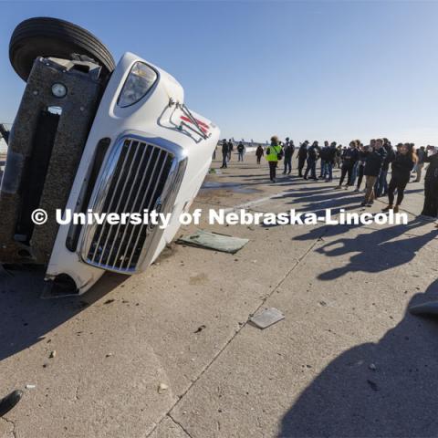 Researchers and invited guests look over the tanker following the crash test. Researchers from the Midwest Roadside Safety Facility conducted a rare tractor-tanker crash to test how a newly designed and significantly less tall concrete roadside barrier performs in a crash. The test was at the facility’s Outdoor Proving Grounds on the western edge of the Lincoln Municipal Airport. December 8, 2021. Photo by Craig Chandler / University Communication.