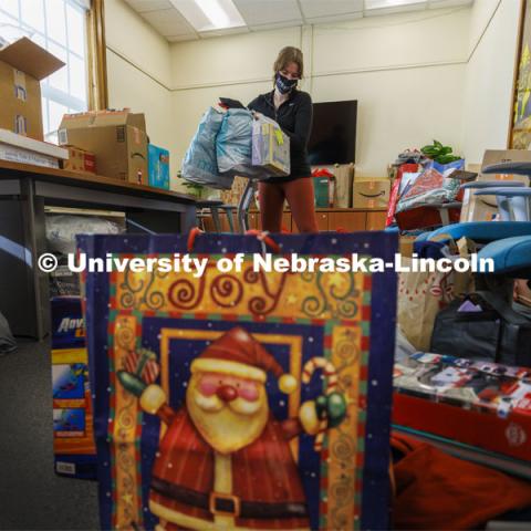 Ashton Koch, senior from Omaha and the outreach coordinator for the Women’s Center, sorts gifts for the Holiday for Little Huskers donation drive. Donations have filled almost every available space in the center. December 9, 2021. Photo by Craig Chandler / University Communication.