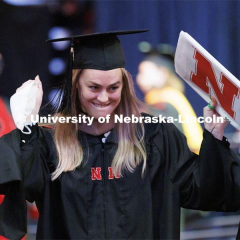 Bonnie Longan celebrates her masters degree as she returns from the stage to her seat. Graduate Commencement at Pinnacle Bank Arena. December 17, 2021. Photo by Craig Chandler / University Communication.