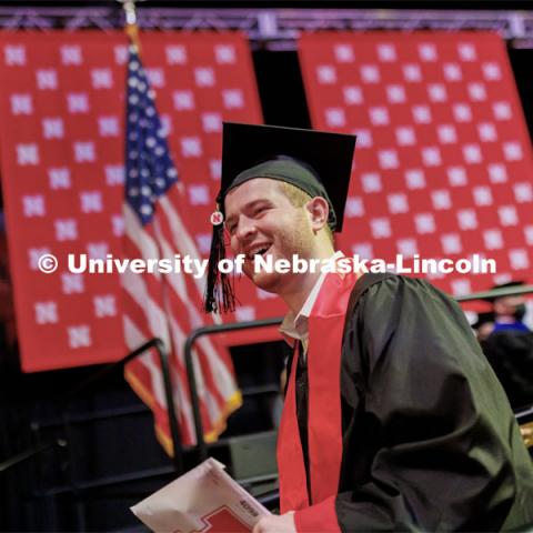 Gabe Luedke smiles as he walks off stage after receiving his CoB diploma. Undergraduate Commencement at Pinnacle Bank Arena. December 18, 2021. Photo by Craig Chandler / University Communication.