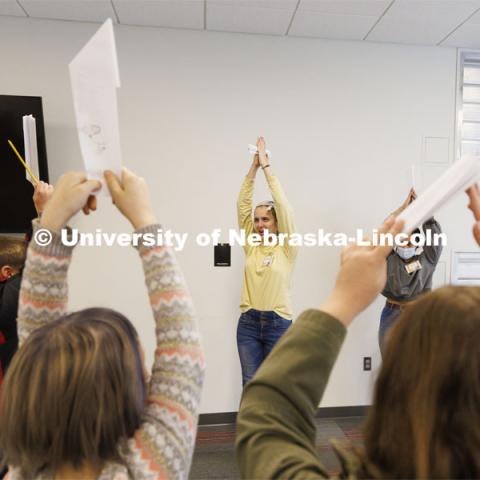 Meagan Heimbrecht, a junior from Lincoln and Brisa Rios, a sophomore from Scottsbluff, have students pretend to be pencils in an ice-breaking exercise during a Winter Break 4-H STEM Challenge at the library in Crete, Nebraska. UNL honors students work as winterns for 4-H/Extension winternships and the Galactic Quest activities. January 4, 2022. Photo by Craig Chandler / University Communication.