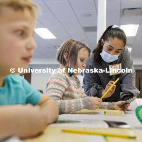 Brisa Rios, a sophomore honors student in psychology and sociology, helps 8-year-old Audrey decode a message using a cipher wheel during a Winter Break 4-H STEM Challenge in Crete, Nebraska. UNL honors students work as winterns for 4-H/Extension winternships and the Galactic Quest activities. January 4, 2022. Photo by Craig Chandler / University Communication.
