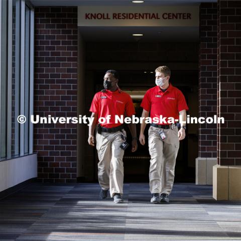 UNLPD Community Service Officers Komlan Akakpo and Trevor Caldwell walk the hallway between Knoll and University Suites. The CSOs are wearing more casual uniforms in 2022. January 7, 2022. Photo by Craig Chandler / University Communication.
