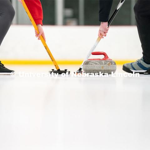 Members of the University of Nebraska Curling Club sweep a curling stone during practice at the John Breslow Ice Hockey. Curling Club. February 1, 2022. Photo by Jordan Opp for University Communication.