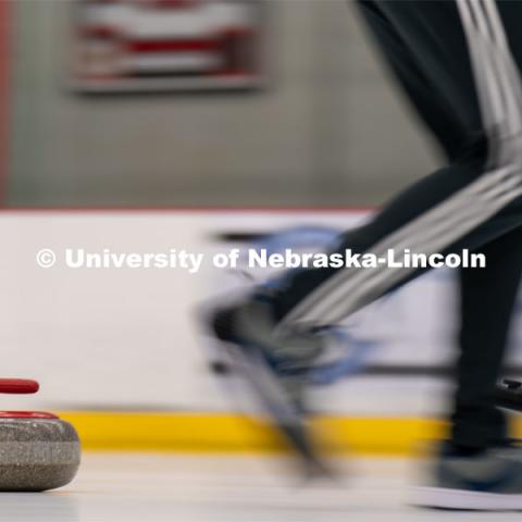 A curling stone moves across the ice at the John Breslow Ice Hockey Center. Curling Club. February 1, 2022. Photo by Jordan Opp for University Communication.
