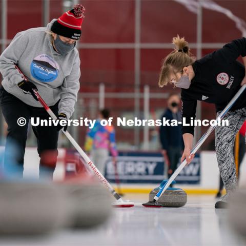 University of Nebraska Curling Club adviser Nancy Myers (left) and Emma Whaley (right) sweep a curling stone during practice at the John Breslow Ice Hockey Center. Curling Club. February 1, 2022. Photo by Jordan Opp for University Communication.