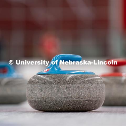 Three curling stones sit on the ice at the John Breslow Ice Hockey Center. Curling Club. February 1, 2022. Photo by Jordan Opp for University Communication.