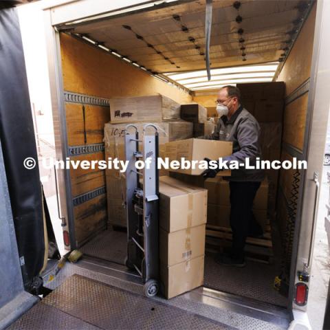 Chad Ebke, a senior material service worker with Facilities Management and Planning-Business Operations, unloads cases of KN95 masks at the Nebraska Union. The masks, which became available on Jan. 28, were picked up by Facilities Management and Planning employees in Omaha on Jan. 31 and distributed to campus sites for sorting on Feb. 1. 150,000 KN95 masks are being distributed on campus this week with each person being given 4 masks. February 1, 2022. Photo by Craig Chandler / University Communication.