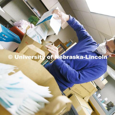 Jon Gayer, Assistant Director of Fraternity and Sorority Life, sorts masks into bags for distribution to Greek houses on Feb. 1. The masks will be distributed to the campus community by a variety of methods. 150,000 KN95 masks are being distributed on campus this week with each person being given 4 masks. February 1, 2022. Photo by Craig Chandler / University Communication.