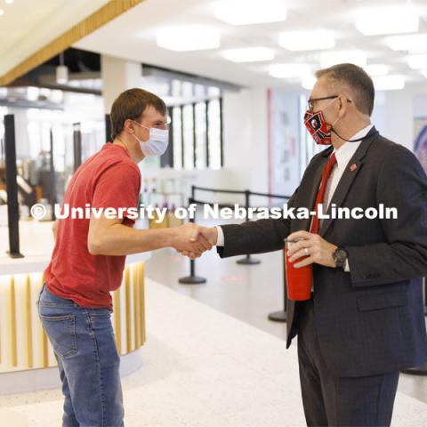 Chancellor Ronnie Green talks with Benjamin Janssen, a junior from Marquette, Nebraska, at the Nebraska East Union Starbucks. Janssen said meeting the Chancellor was on his bucket list while he is at Nebraska. Chancellor Green provided free drip coffee from Starbucks on City and East campuses in celebration of Glow Big Red. February 16, 2022. Photo by Craig Chandler / University Communication.