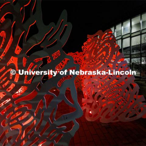 The sculpture Reverie is lit up red outside the  International Quilt Study Center and Museum for Glow Big Red. February 16, 2022. Photo by Craig Chandler / University Communication. 