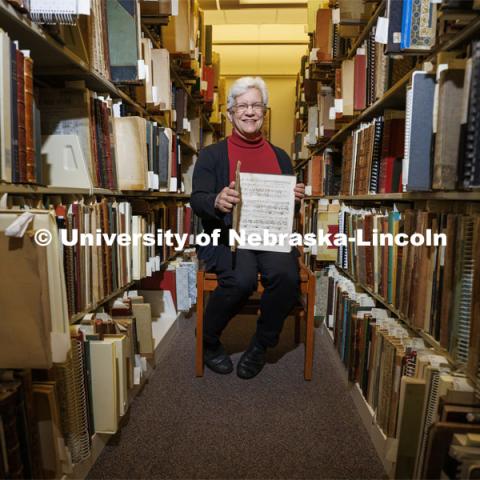 Anita Breckbill, professor, sits amongst the stacks of music. Breckbill oversees the Hixon-Lied School of Fine and Performing Arts music library in the basement of the Westbrook Music Center. March 18, 2022. Photo by Craig Chandler / University Communication.