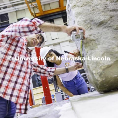 Mohammadreza Farooghi Mehr and Gabriela Yáñez mark a slab on a large shake table in Christine Wittich’s structures lab in Scott Engineering Center. College of Engineering photo shoot. March 22, 2022. Photo by Craig Chandler / University Communication.