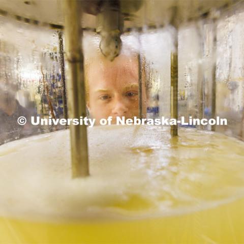 Josiah Kolar examines a bioreactor in Hunter Flodman’s UO Lab. College of Engineering photo shoot. March 22, 2022. Photo by Craig Chandler / University Communication.