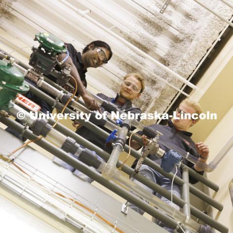 Aingaran Bala Raman, Ethan Yungdahl and Josiah Kolar examine equipment in Hunter Flodman’s UO Lab. College of Engineering photo shoot. March 22, 2022. Photo by Craig Chandler / University Communication.