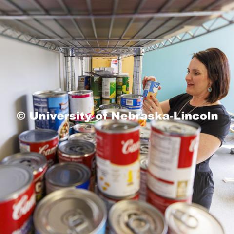 Emily Griffin Overocker, Fine and Performing Arts' Student Success Coordinator, arranges the shelves in the new pop-in pantry in the Hixson-Lied Student Success Center. The center in the Woods Art Building opens Thursday March 24. March 21, 2022. Photo by Craig Chandler / University Communication.