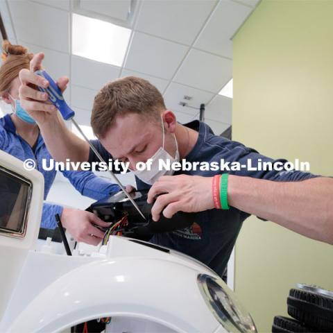 Ethan Bowles, a senior biological systems engineering major, makes an adjustment to the steering wheel in an electric car during the GoBabyGo! Build. His team is modifying the car for four-year-old Dayana Torres of Omaha. Bowles was among seven Huskers to assist with the project. This was his third time volunteering for the event.

Twice yearly, Nebraska’s Go Baby Go chapter modifies kid-sized battery powered cars for children with movement difficulties, providing them at no cost to the families. Nebraska’s GoBabyGo! chapter is funded by the Munroe-Meyer Guild. The program is a partnership between MMI's Department of Physical Therapy, the University of Nebraska-Lincoln and the University of Nebraska-Omaha Engineering Department and the UNMC College of Allied Health Professions/Physical Therapy students. The event took place on at the MMI building at 69th and Pine Streets in Omaha on Saturday, April 2, 2022. Photo by Kent Sievers / University of Nebraska Medicine.

