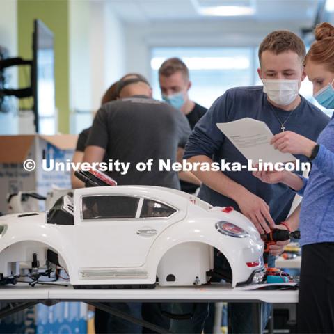 UNL engineering student Ethan Bowles, right, and UNMC physical therapy student Jaime Troester modify a battery-powered car for four-year-old Dayana Torres of Omaha.

Twice yearly, Nebraska’s Go Baby Go chapter modifies kid-sized battery powered cars for children with movement difficulties, providing them at no cost to the families. Nebraska’s GoBabyGo! chapter is funded by the Munroe-Meyer Guild. The program is a partnership between MMI's Department of Physical Therapy, the University of Nebraska-Lincoln and the University of Nebraska-Omaha Engineering Department and the UNMC College of Allied Health Professions/Physical Therapy students. The event took place on at the MMI building at 69th and Pine Streets in Omaha on Saturday, April 2, 2022. Photo by Kent Sievers / University of Nebraska Medicine.

