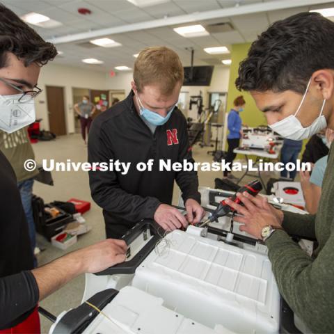 University of Nebraska students (from left) Ricardo Gato Gil, Chandler Brock and Eduardo Mendoza solder wires together as they modify the gas pedal in a GoBabyGo! car. 

Twice yearly, Nebraska’s Go Baby Go chapter modifies kid-sized battery powered cars for children with movement difficulties, providing them at no cost to the families. Nebraska’s GoBabyGo! chapter is funded by the Munroe-Meyer Guild. The program is a partnership between MMI's Department of Physical Therapy, the University of Nebraska-Lincoln and the University of Nebraska-Omaha Engineering Department and the UNMC College of Allied Health Professions/Physical Therapy students. The event took place on at the MMI building at 69th and Pine Streets in Omaha on Saturday, April 2, 2022. Photo by Kent Sievers / University of Nebraska Medicine.

