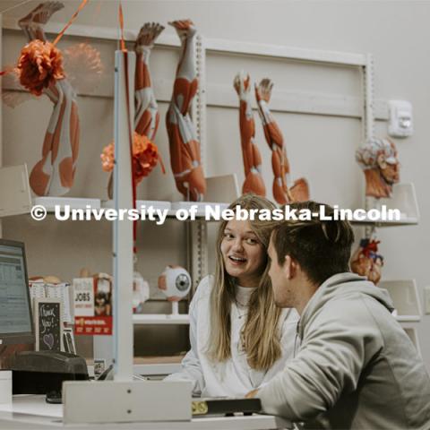 Madelyn Thompson helps Daniel Stara with a question at the Help Desk in Love Library South. Behind them are anatomy models that can be checked out. April 6, 2022. Photo by Craig Chandler / University Communication.