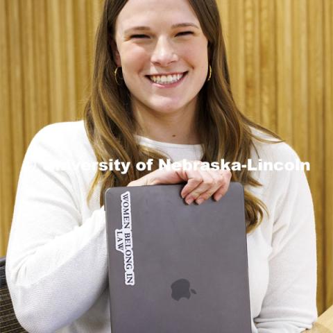 A student shows a sticker on her laptop "Women Belong in Law". College of Law photo shoot. April 20, 2022. Photo by Craig Chandler / University Communication.