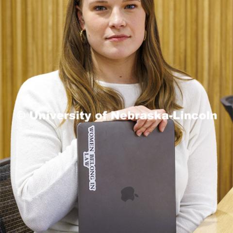 A student shows a sticker on her laptop "Women Belong in Law". College of Law photo shoot. April 20, 2022. Photo by Craig Chandler / University Communication.
