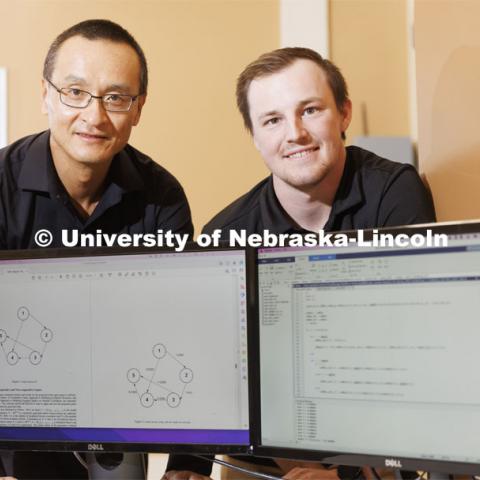 Professor Qing Hui and graduate student Josh Allen pose in their lab in Nebraska Hall. A NSRI funded study will demonstrate how the theoretic and computational tools developed in this field can be used to counter weapons of mass destruction (WMD). It will also raise challenging technical questions about how to evaluate the effectiveness of these tools for solving a multi-domain, complex problem to obtain a satisfactory solution.  April 22, 2022. Photo by Craig Chandler / University Communication.