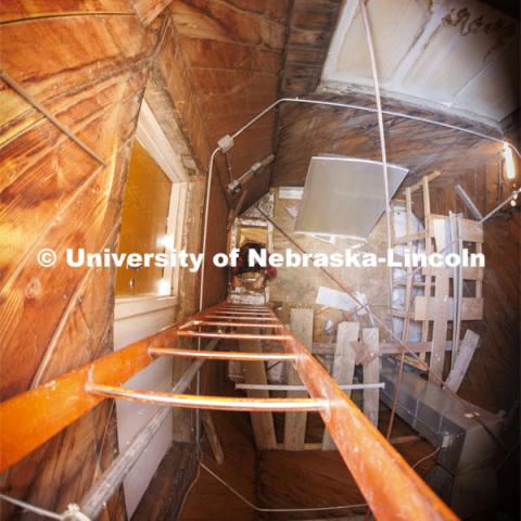 Erin Colonna, graphic designer with the University Libraries, climbs down the ladder from the Love Library Cupola. The cupola will be renovated this summer following spring commencement. April 25, 2022. Photo by Craig Chandler / University Communication.