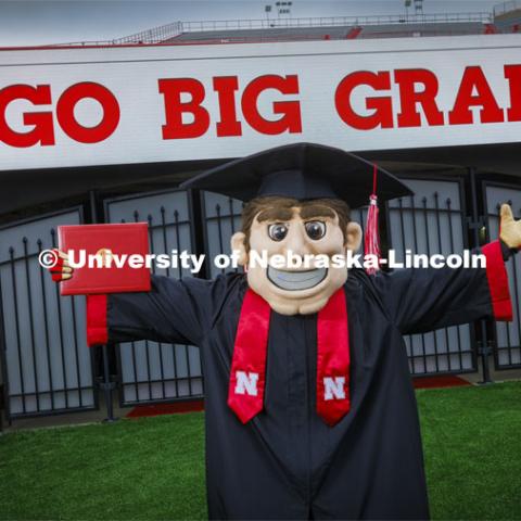Herbie Husker in cap and gown to promote 2022 spring commencement in Memorial Stadium. May 4, 2022. Photo by Craig Chandler / University Communication.