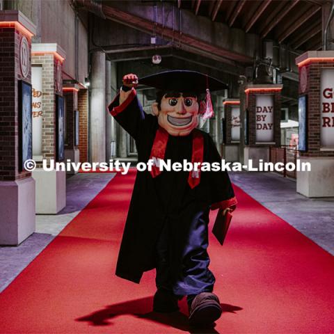 Herbie Husker in cap and gown to promote 2022 spring commencement in Memorial Stadium.  May 4, 2022. Photo by Craig Chandler / University Communication.
