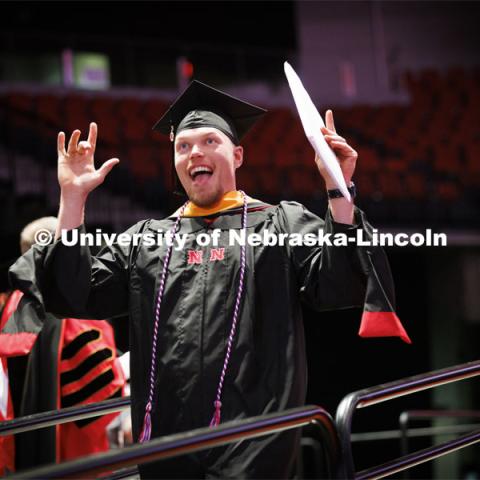 Sheldon Brummel gestures to family after receiving his masters degree. Graduate commencement in Pinnacle Bank Arena. May 13, 2022. Photo by Craig Chandler / University Communication.