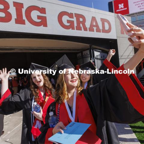 Jenica Ross takes a selfie with friends Samantha Towne, left, and Keisha Widjaja as they enter Memorial Stadium. UNL undergraduate commencement in Memorial Stadium. May 14, 2022.  Photo by Craig Chandler / University Communication.