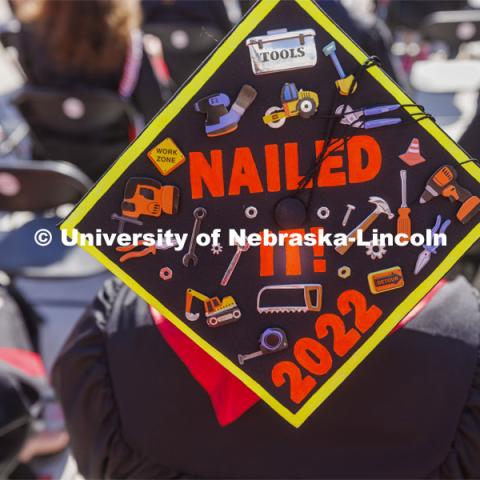 Rodrigo Venegas, First-gen, Marine, non-traditional student, veteran, construction management major, from Grand Island, shows off his decorated mortar board. UNL undergraduate commencement in Memorial Stadium. May 14, 2022. Photo by Craig Chandler / University Communication.