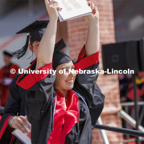 Mia Spedale shows off her UNL diploma to friends and family. UNL undergraduate commencement in Memorial Stadium. May 14, 2022. Photo by Craig Chandler / University Communication.