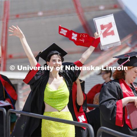 Kira Taylore waves to family and friends after receiving her diploma. UNL undergraduate commencement in Memorial Stadium. May 14, 2022. Photo by Craig Chandler / University Communication.